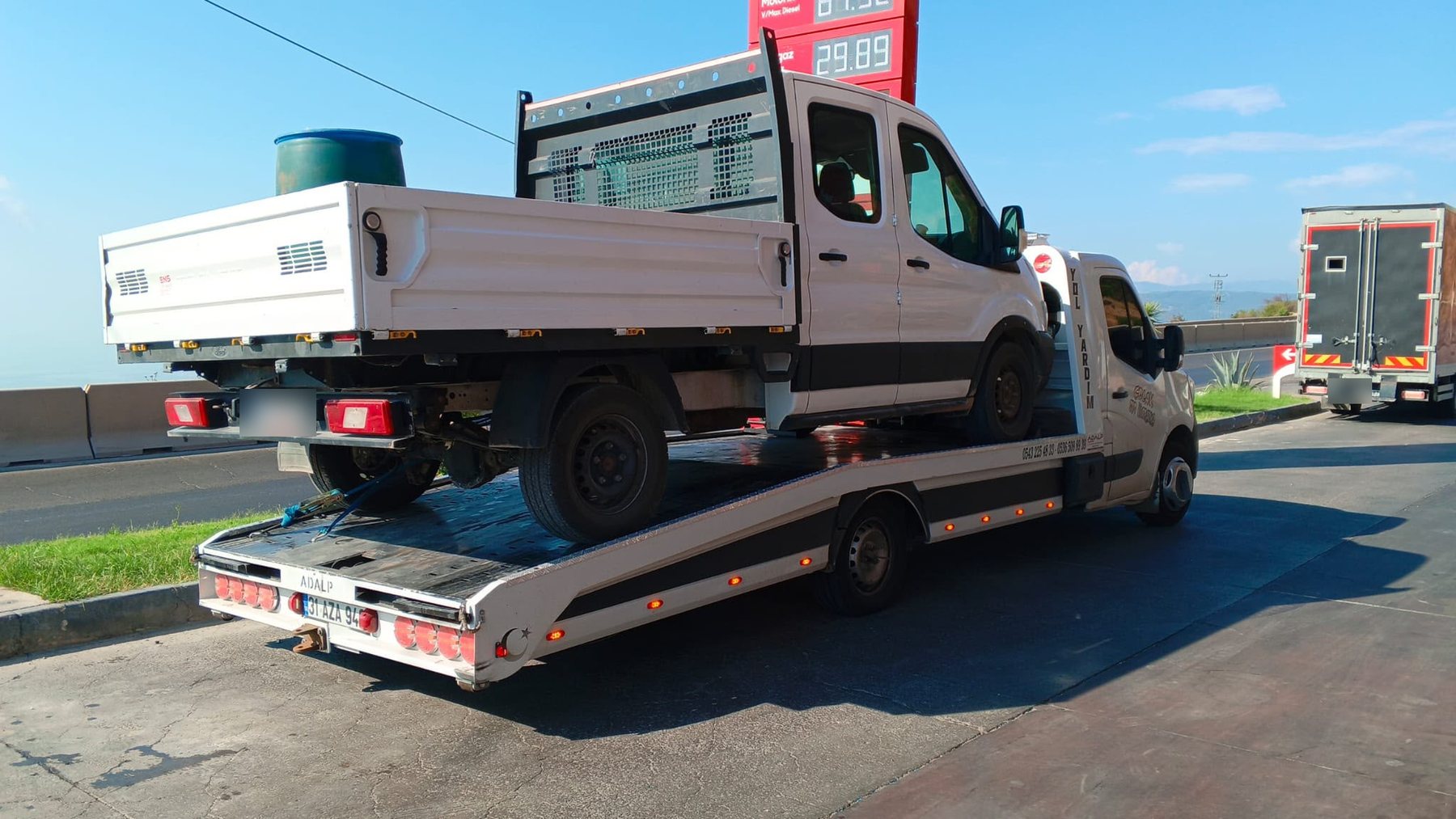 Akaryakıt istasyonunda kasasında çift kabin kamyonet taşıyan Çolak Oto Kurtarma çekicisi